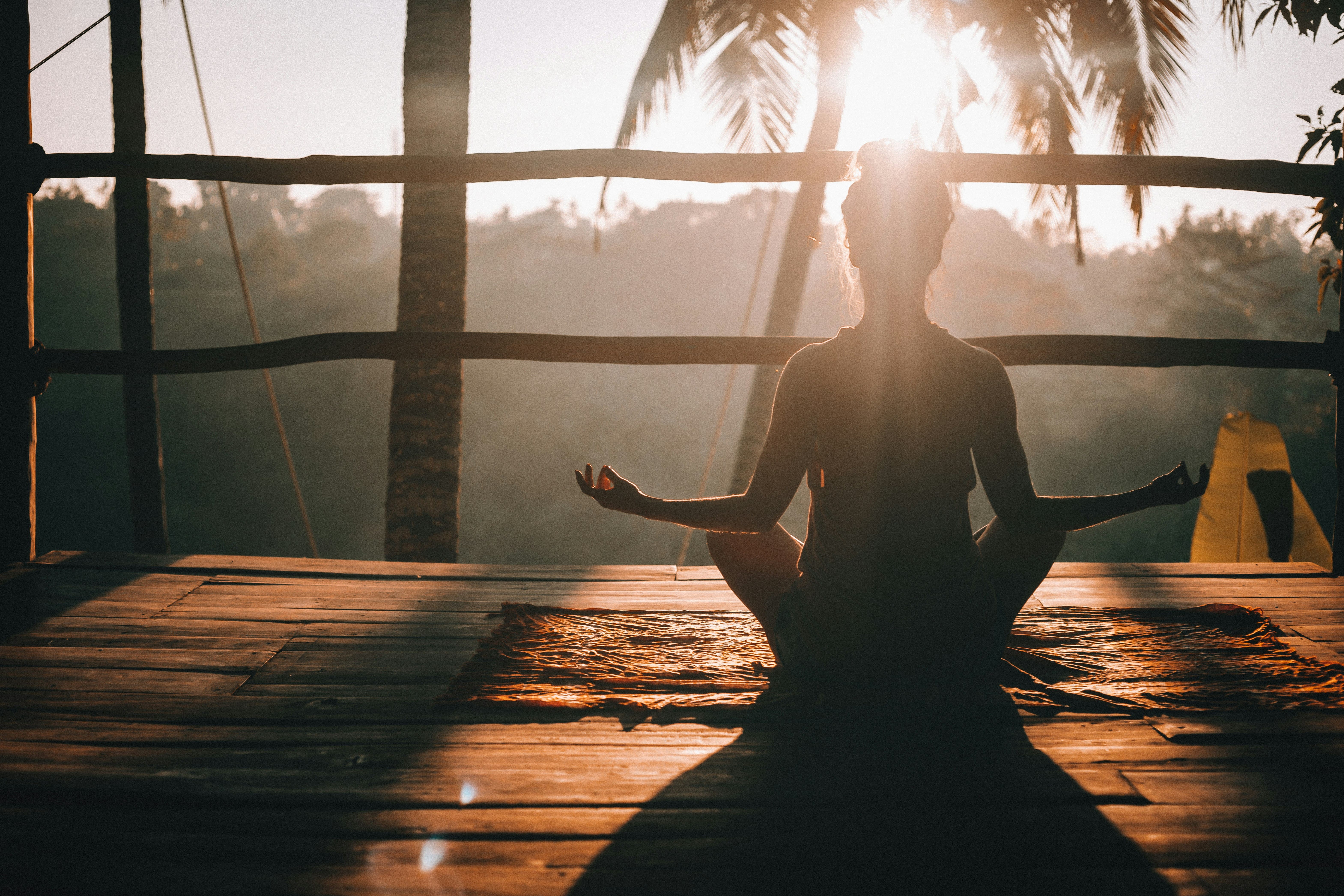 Girl meditating sitting in front of the jungle.